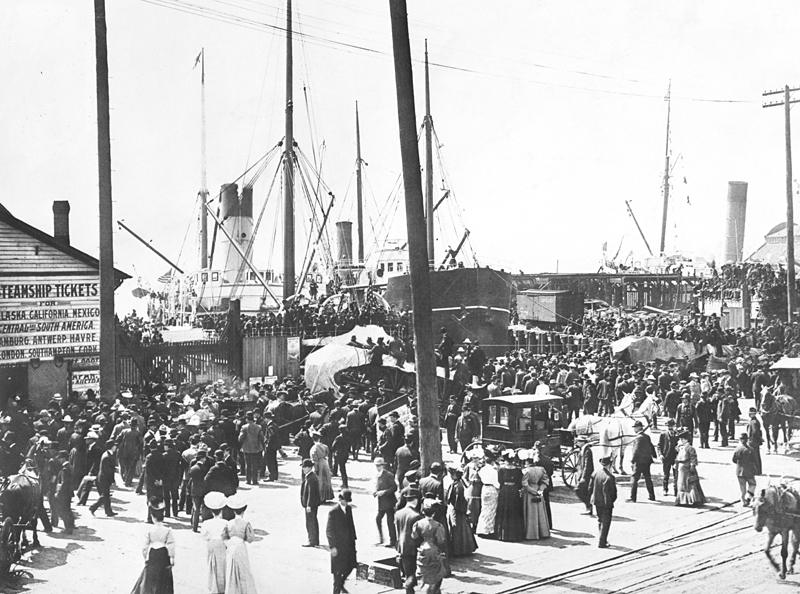 Crowds gathered at Schwabacher's Wharf in Seattle on Independence Day July 4th 1897 with ships moored in the harbour